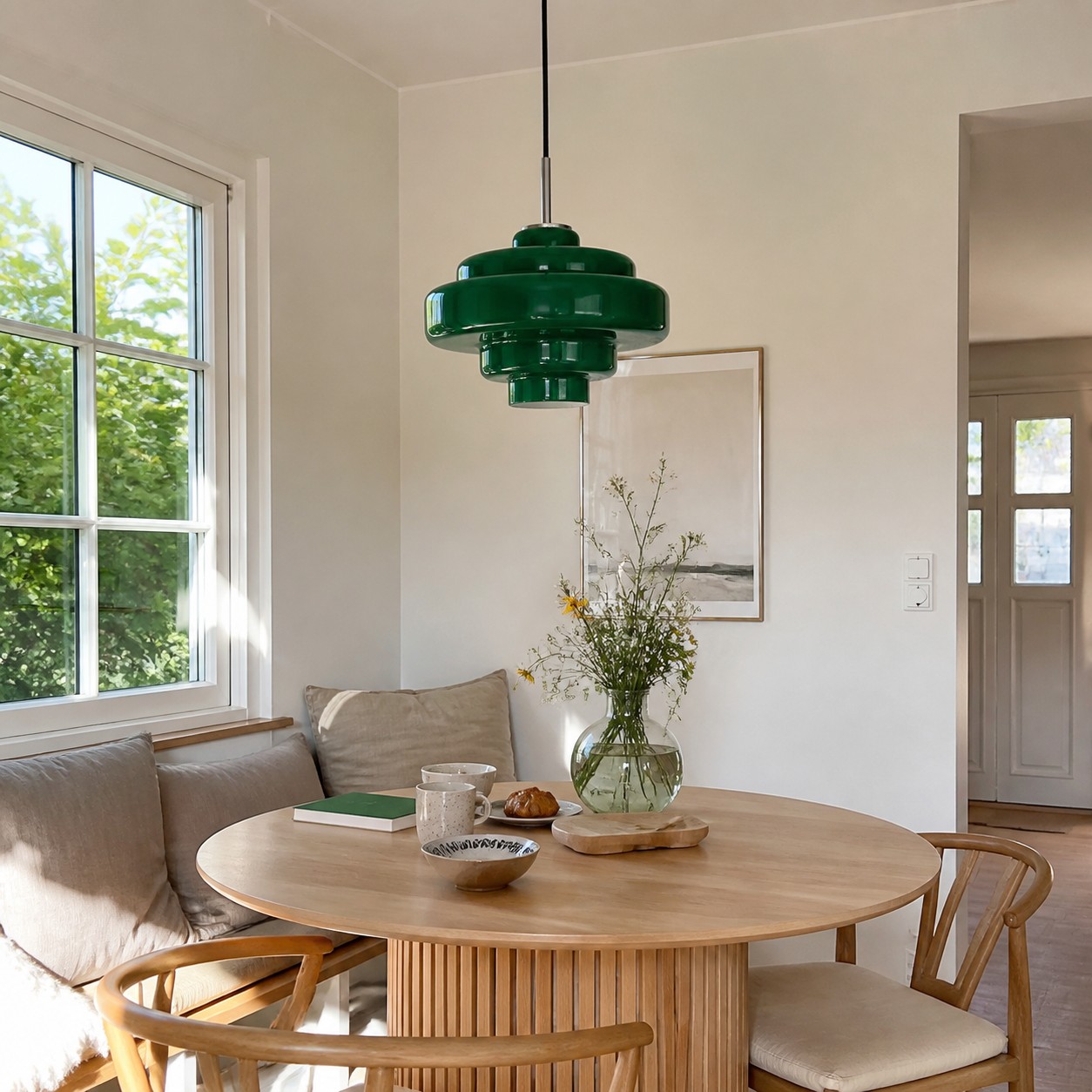 A soft green glass pendant styled in a calm Scandi-inspired breakfast nook.