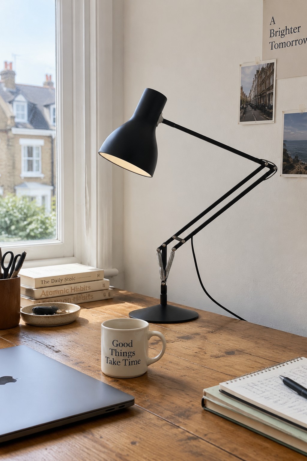 A black adjustable desk lamp beside a window