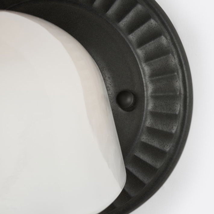 Close view of dark fluted wall plate and white shade