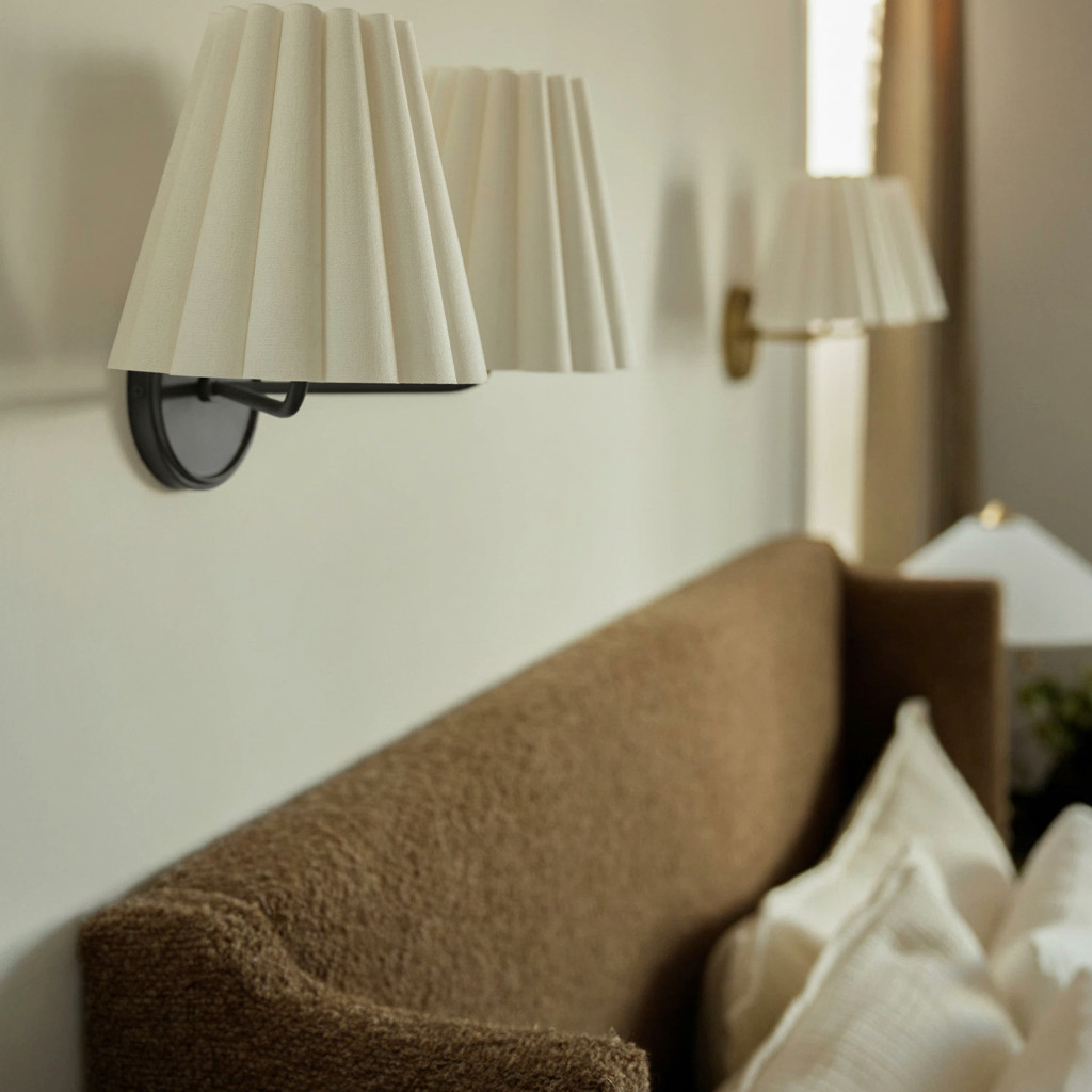 Customer close-up of Ruffmeto wall sconces near a sofa