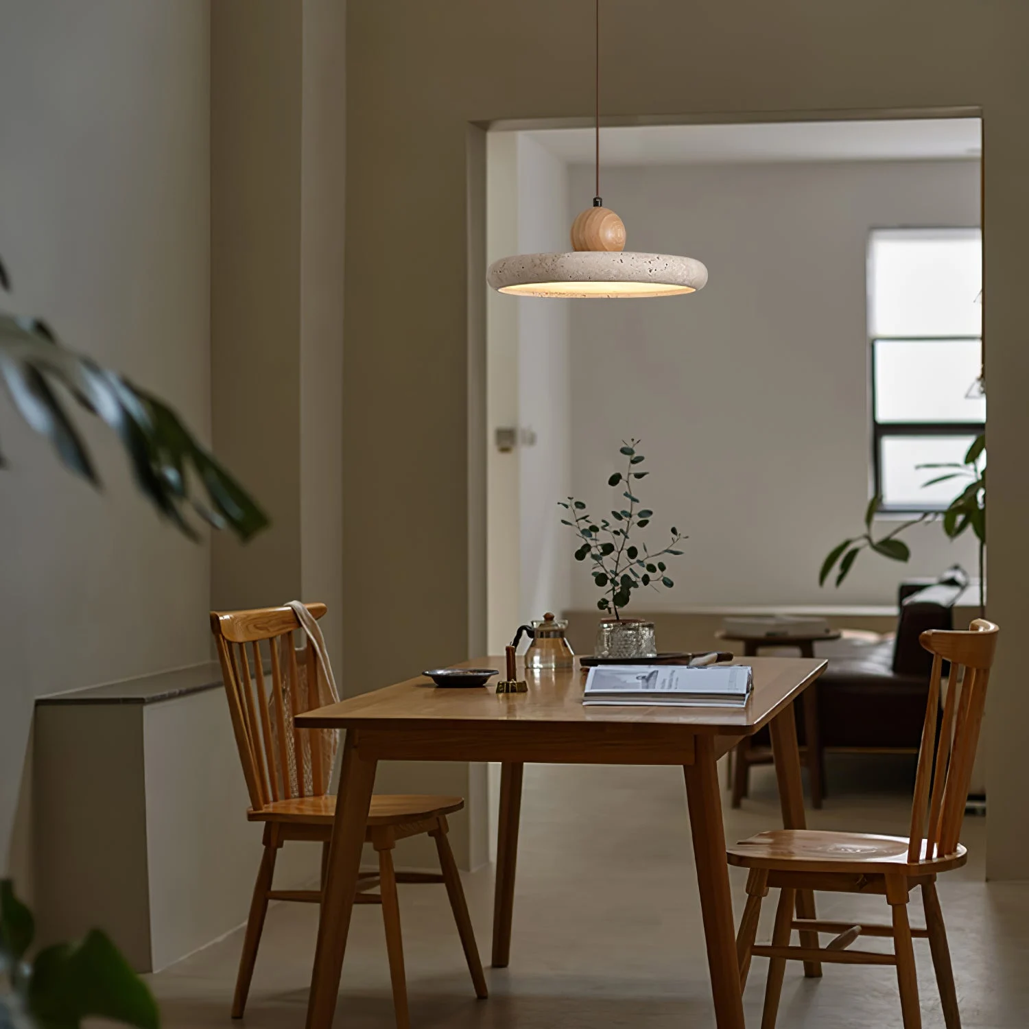Travertine pendant light above a small dining table