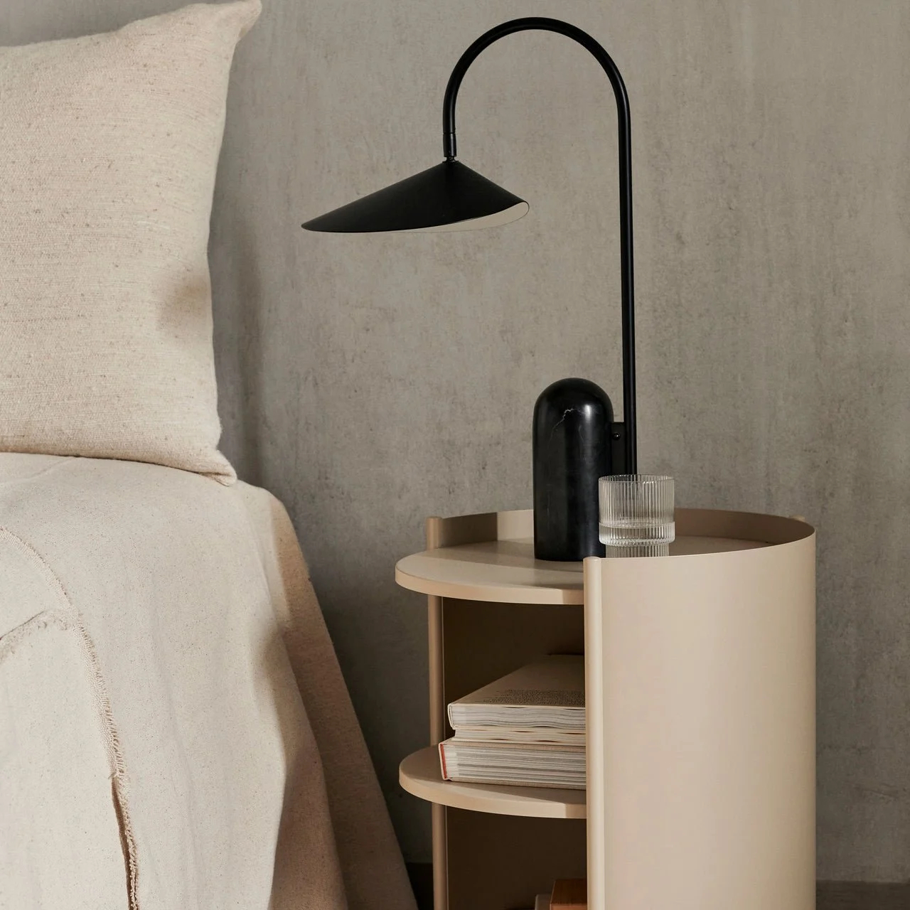 Black table lamp beside a bed