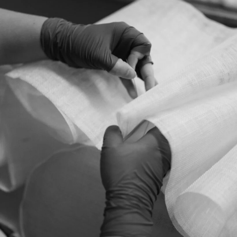 Hands shaping abaca fibre fabric folds