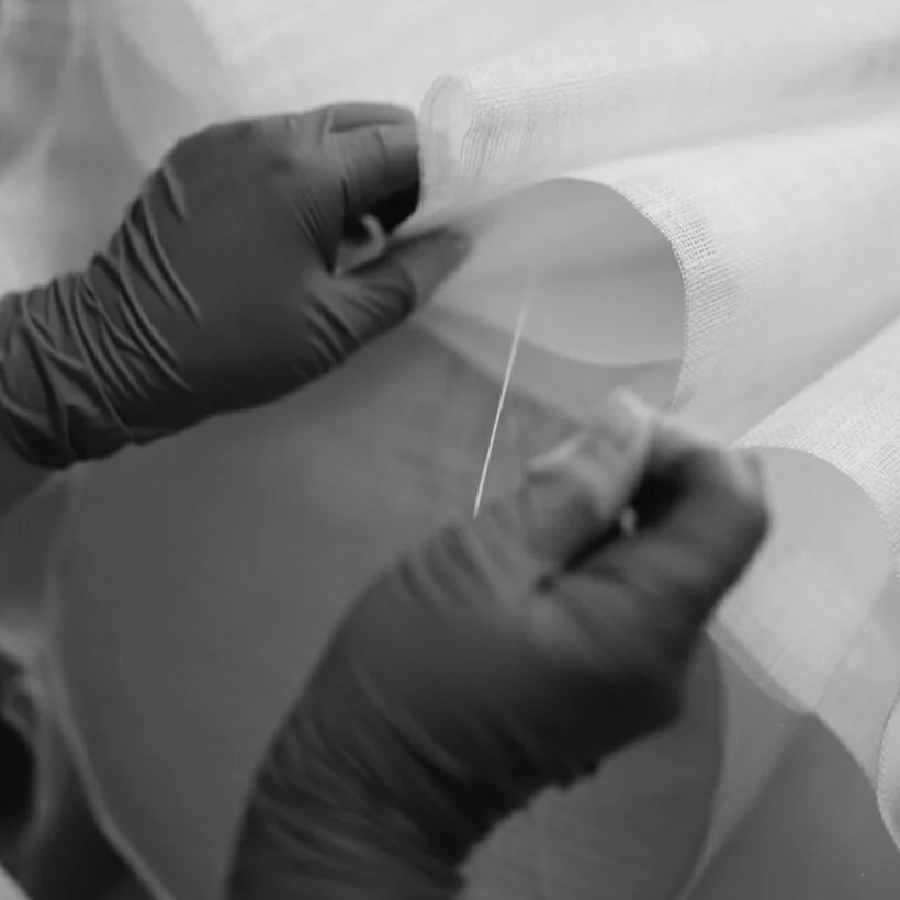 Carefully stitching pleated fabric folds