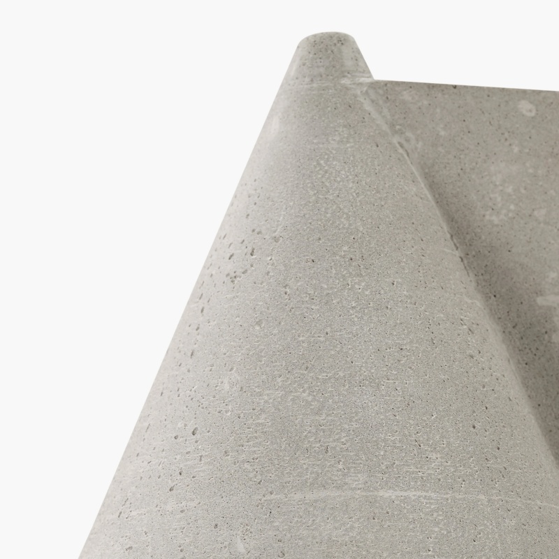 Close-up of the tapered gray concrete wall lamp form