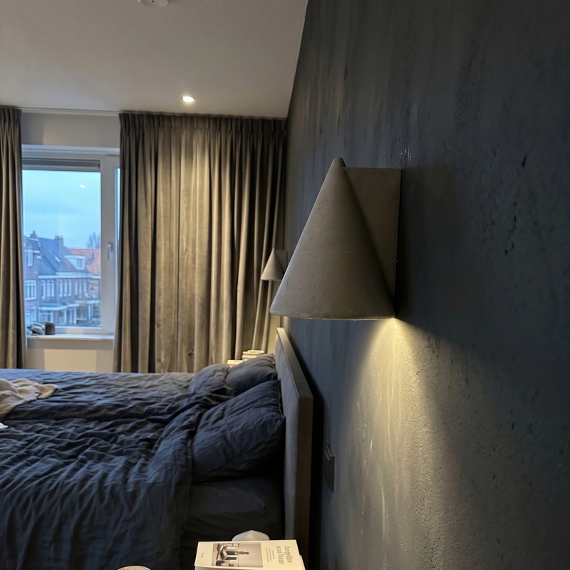 Concrellia wall lamp casting warm light in a bedroom