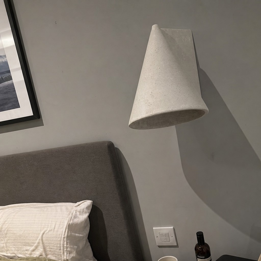 Gray Concrellia lamp beside a bed