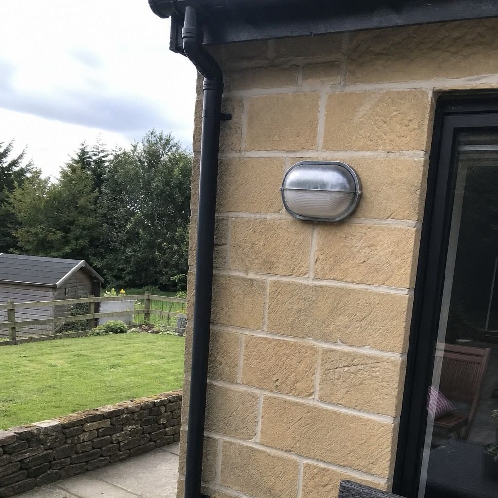 Customer installation of Docka wall sconce on exterior stone wall