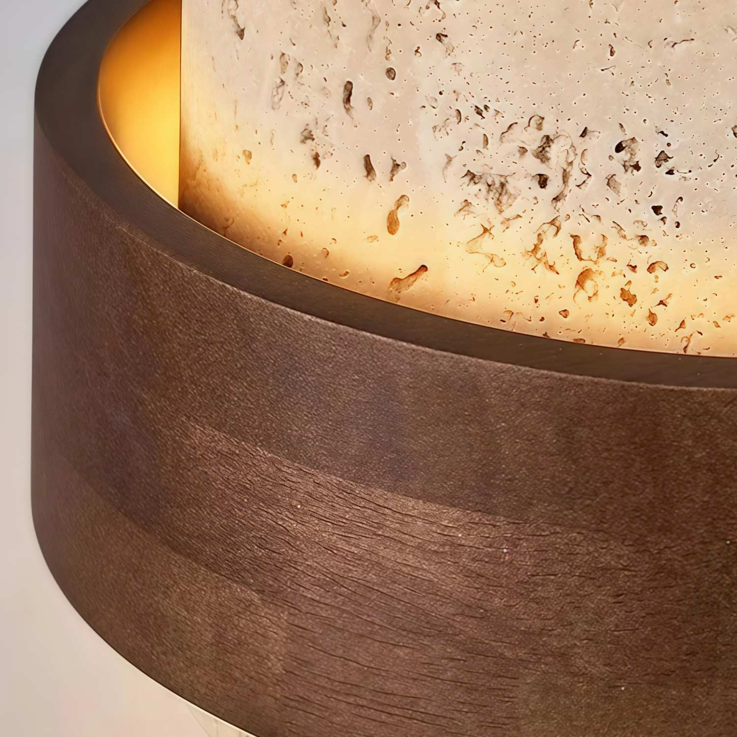 Warm licht dat door het getextureerde travertijn lamplichaam valt
