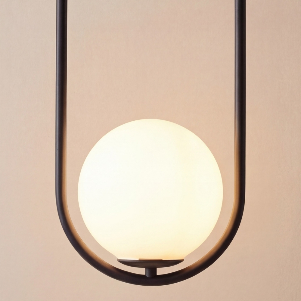 Close-up of Lunectra pendant light glass sphere and black frame