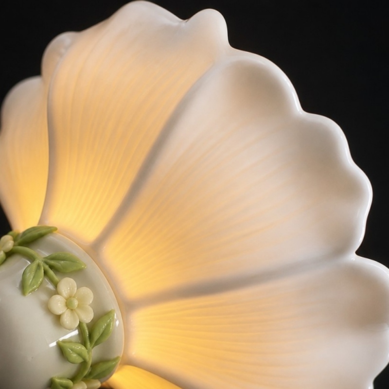 Warm light glowing through the petal-shaped ceramic shade