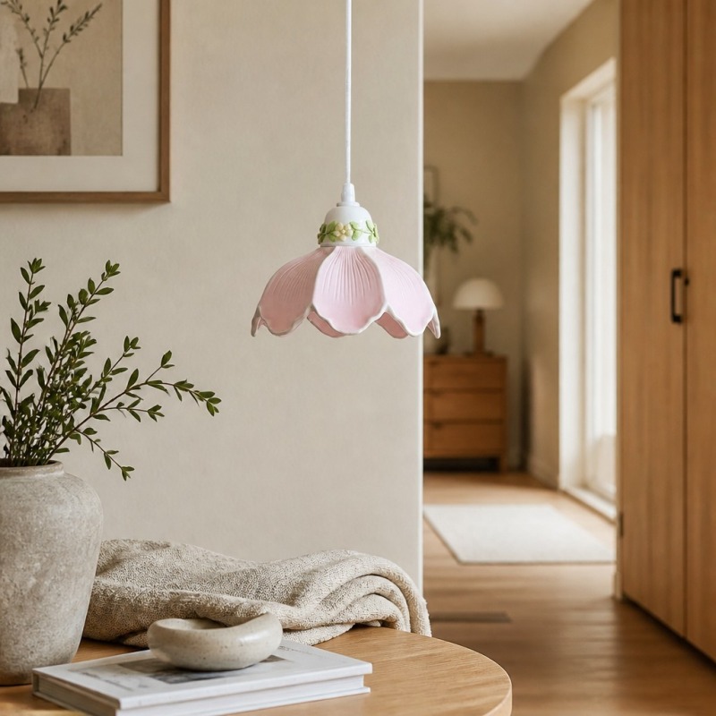Pink flower pendant lamp above a bedside table