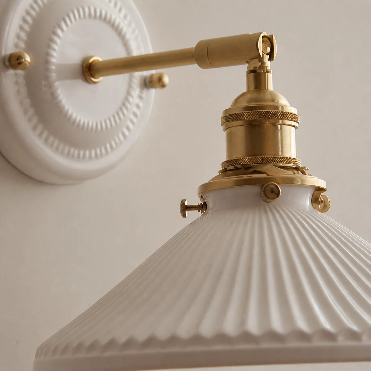 Close view of the ceramic shade and brass wall lamp detail