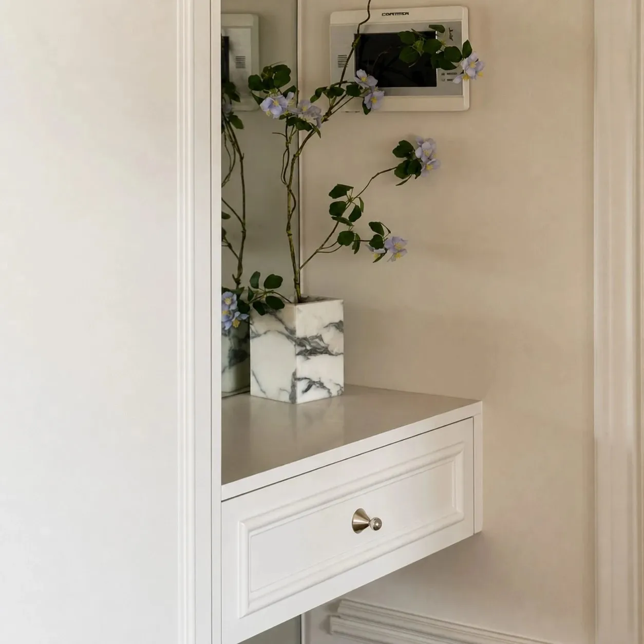 Polished cabinet knobs styled on an entryway cabinet