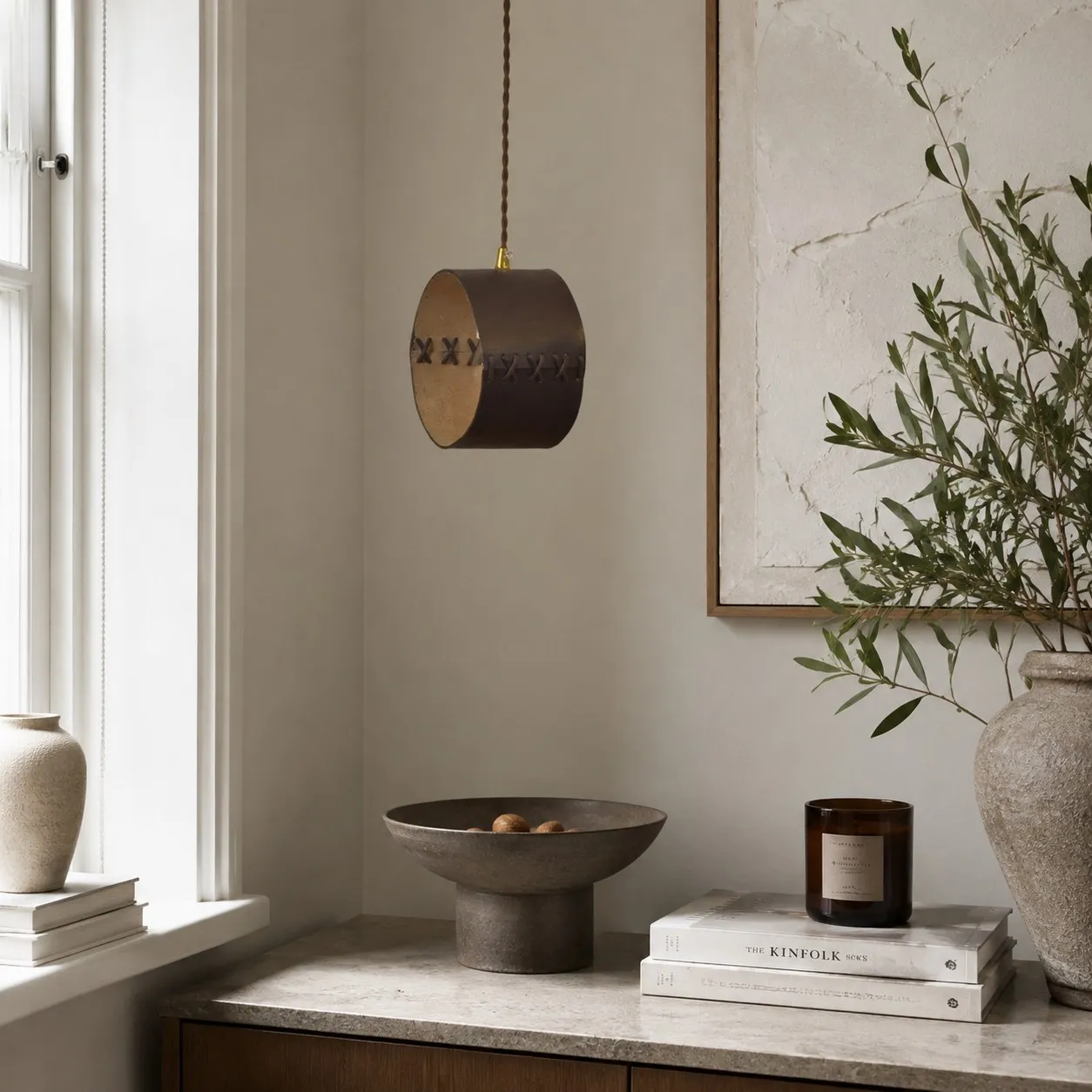 Hand-laced leather cylinder pendant light in an interior setting
