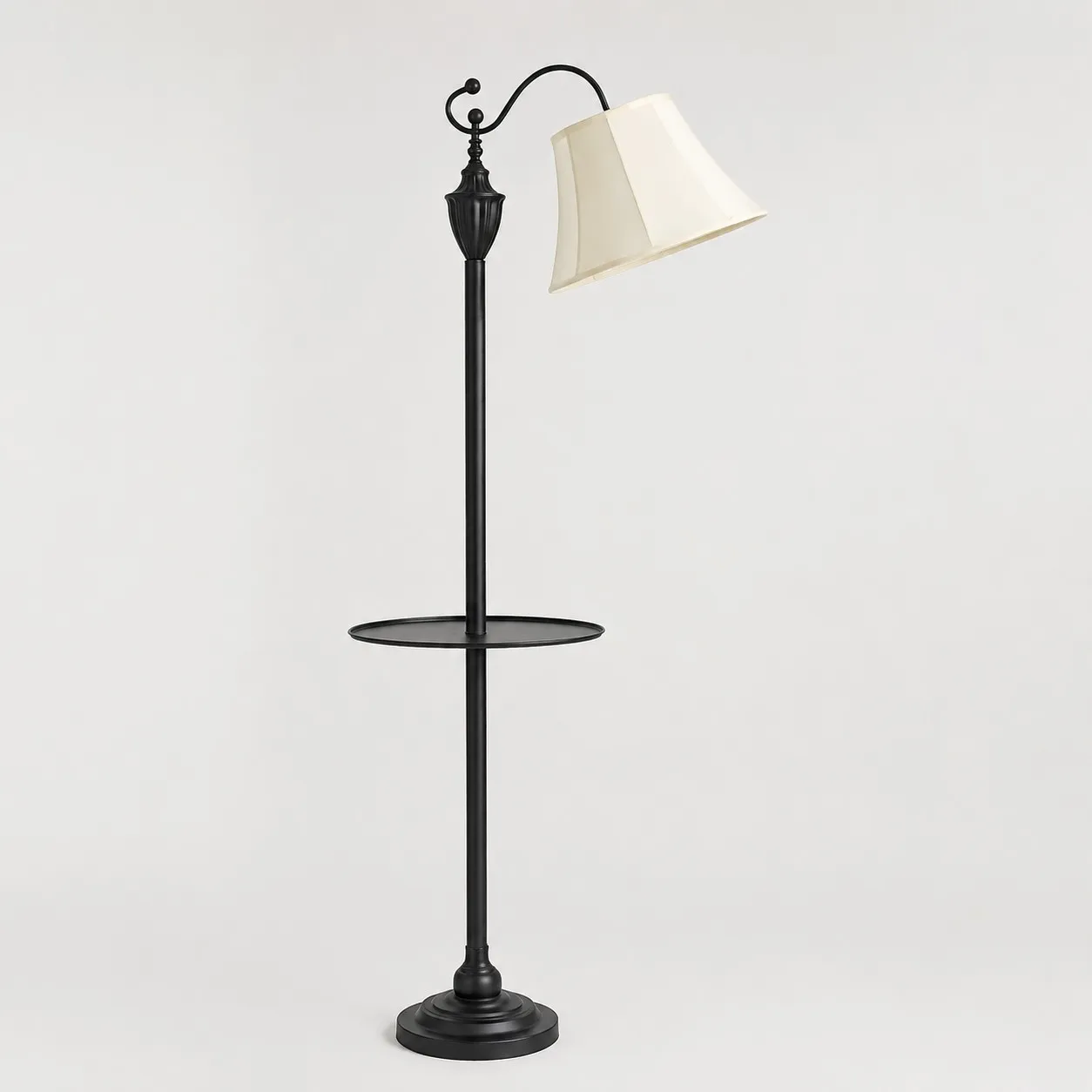 Full view of vintage black arc floor lamp with beige fabric shade and round side table