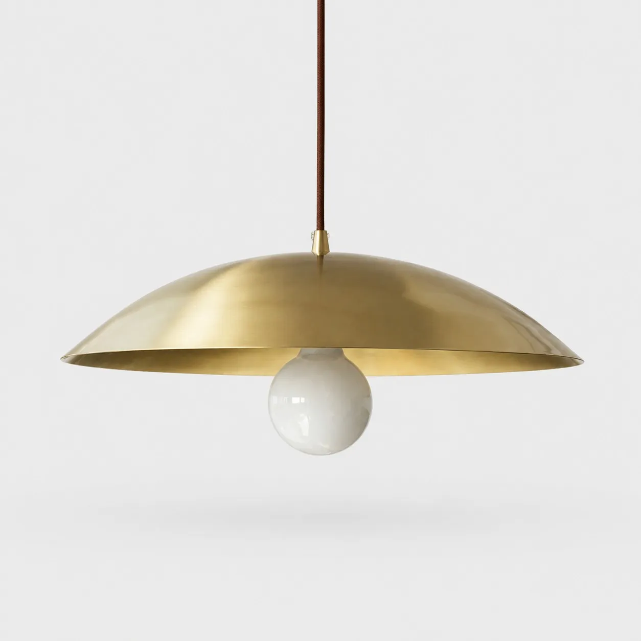 Brushed brass-finish dome pendant light on a neutral background