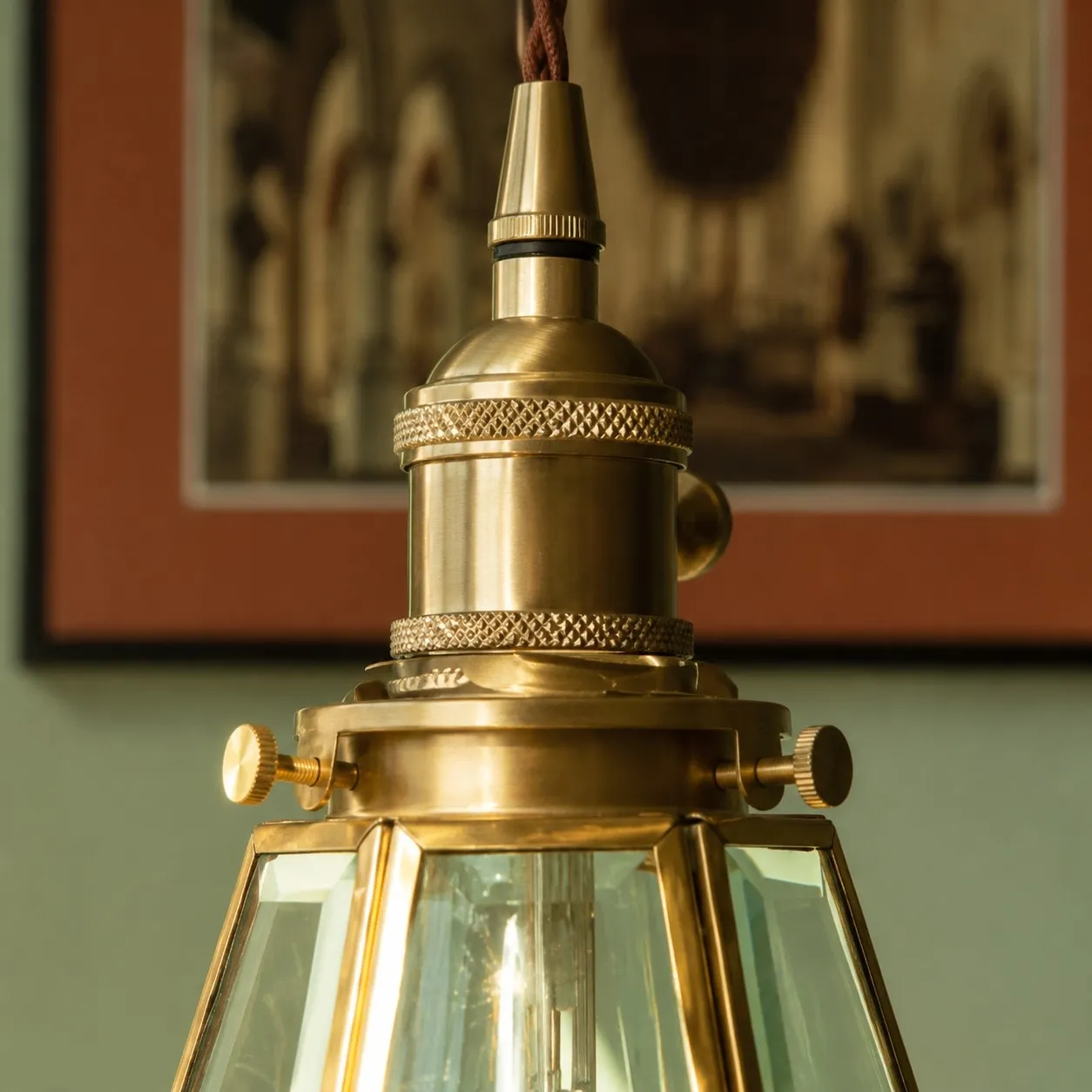 Close view of brass pendant cap and clear glass shade