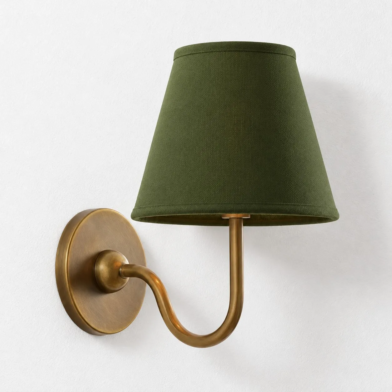 Green plain linen shade on a tumbled brass wall lamp
