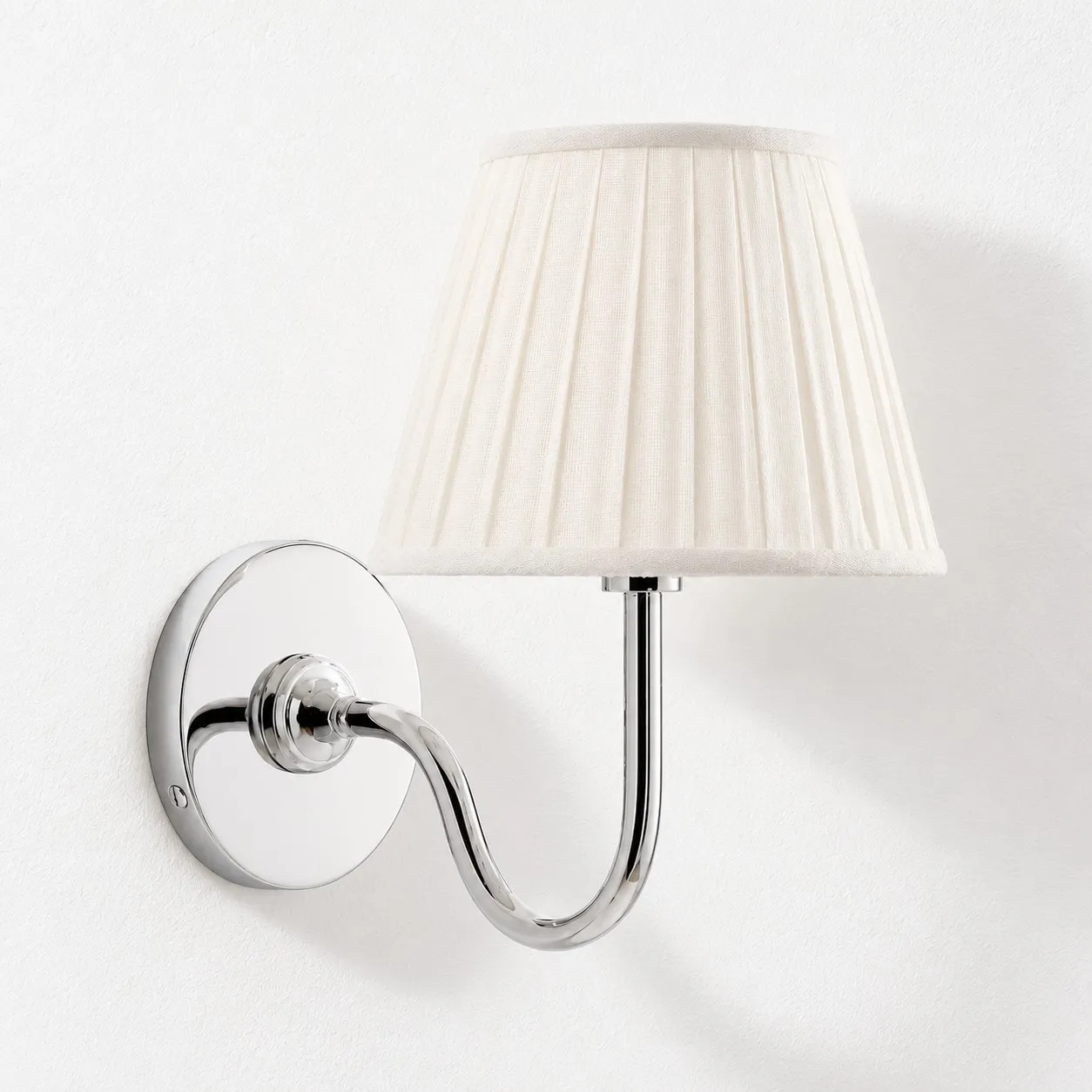 Chrome wall lamp with a white pleated linen shade