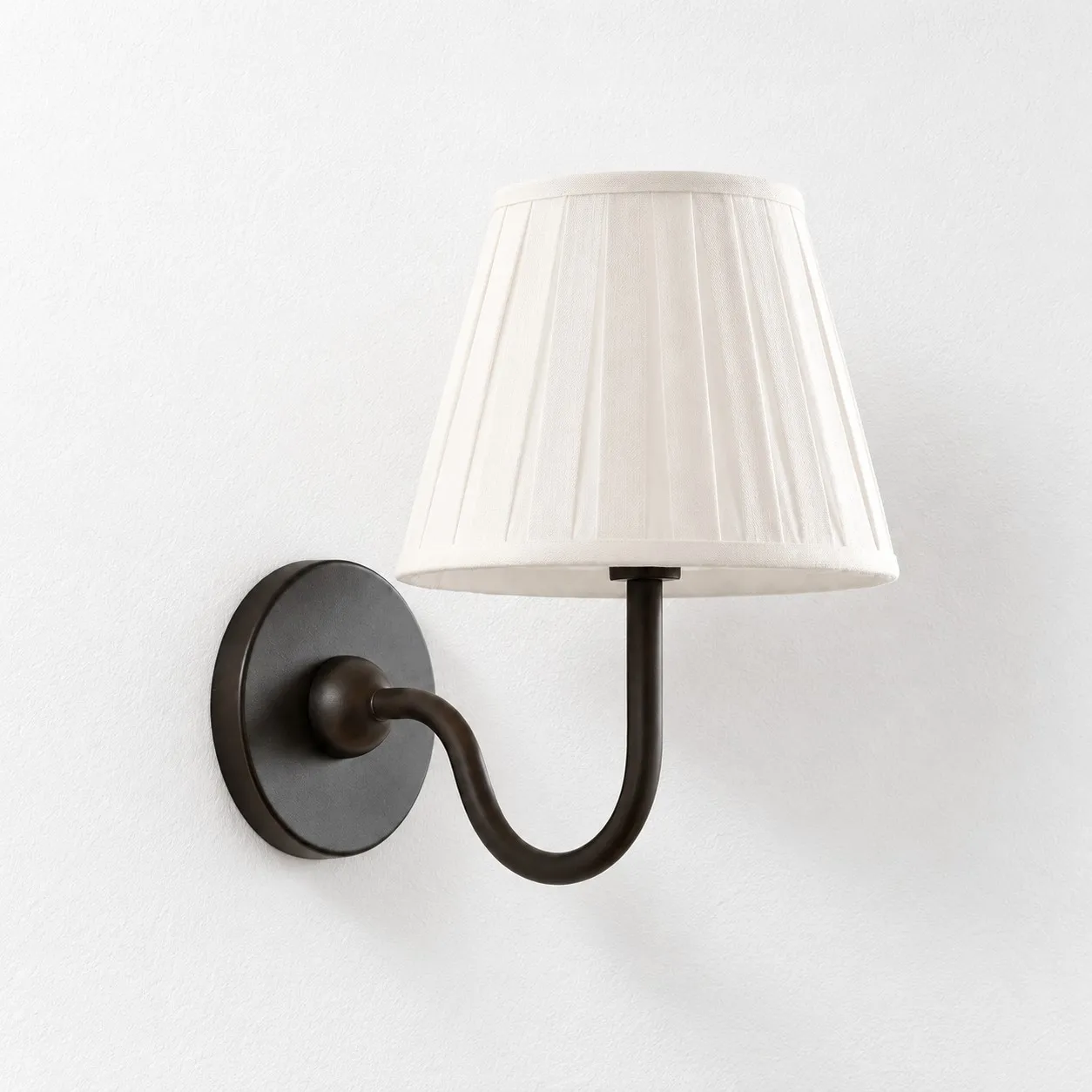 Matte black wall lamp with a white pleated linen shade