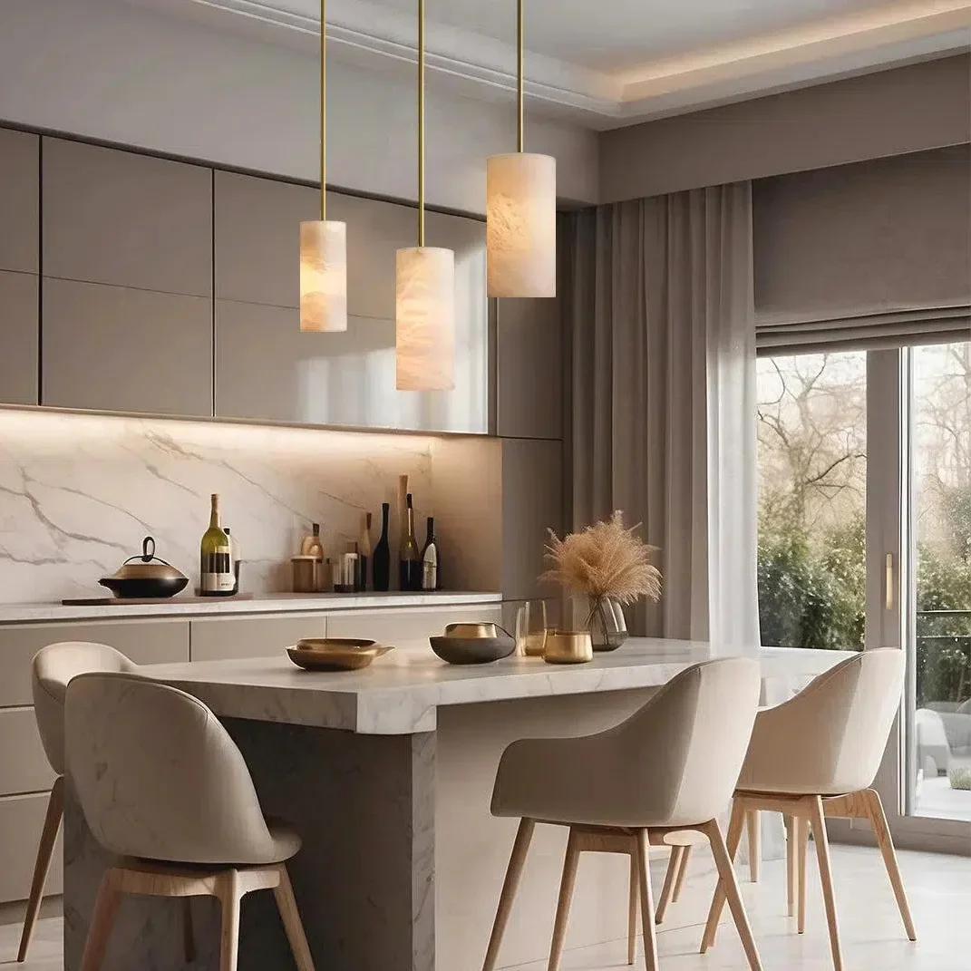 Alabaster cylinder pendant lights over a kitchen island